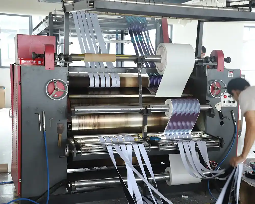 A machine printing a custom pattern onto a roll of webbing.