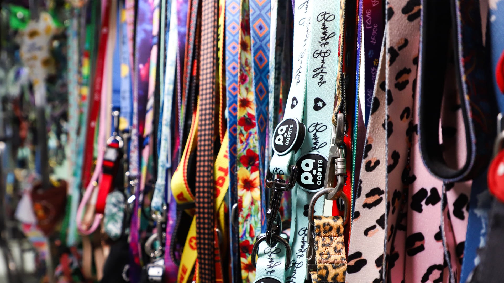 A handshake over a table of colorful custom pet product samples.